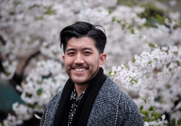 Taoxin (Xin) Wang standing in front of white blossoms