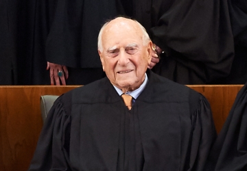 Older man in tie and black judge's robe