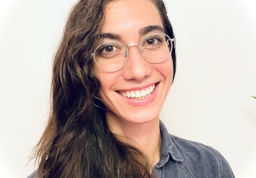 Young woman with wire rim glasses and long brown hair. 