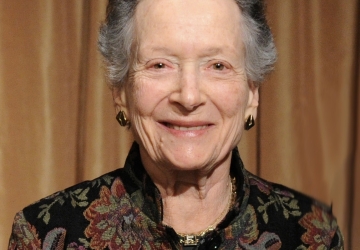 Woman with gray hair in dark flowered jacket