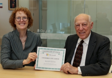 Woman and man, seated side by side, hold stock certificate