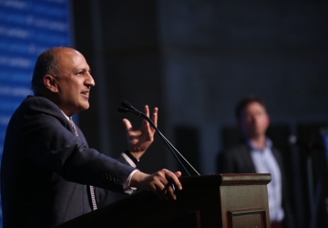 Man speaking and gesturing at podium
