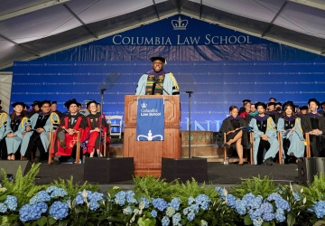 Stage of Columbia Law graduation with hydrangeas and dignitaries