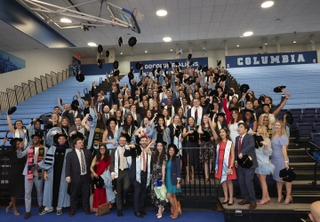 Members of the Classes of 2021 and 2020 standing on bleachers