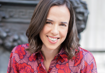 Woman with brown hair in colorful patterned blouse