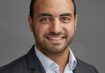 Bearded man with cropped hair in grey jacket