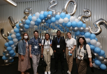 Six members of the class of 2025 pose in front of blue and white balloon arch with additional silver balloons that spell out CLS 2025.