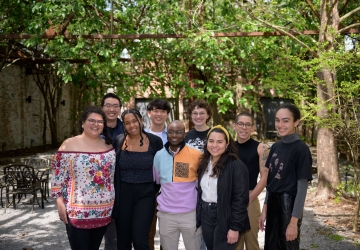 Group of nine law students standing in a shady courtyard