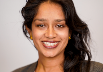 Smiling woman with long dark hair, in dark jacket