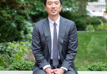 Professor Dennis Tan in suit and tie sitting outside