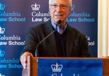 Jim Millstein in glasses behind a Columbia Law School podium