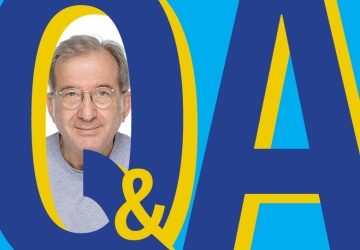 Blue graphic Q&A with photo of gray haired man with glasses.