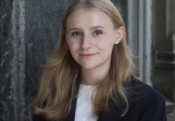 Young woman with long blonde hair in white shirt and black jacket