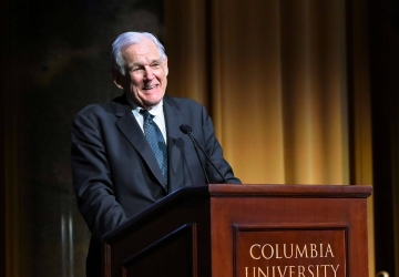 Professor George Bermann in suit and tie speaking in front of a Columbia University podium