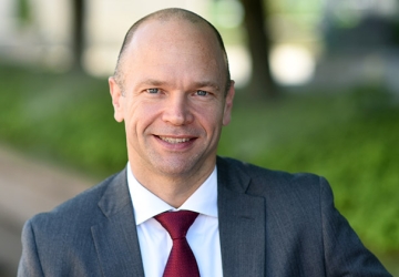 A close-up portrait of a smiling Professor Justin McCrary