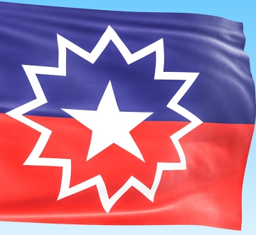 Flag for Juneteenth showing a purple and red stripe and white star inside of a starburst.