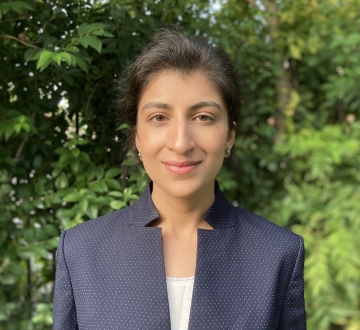 Columbia Law professor Lina Khan in blue jacket and white camisole