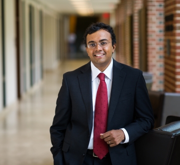 Law professor in black suit and red tie