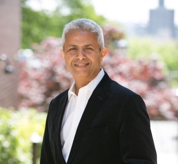 Silver-haired man in white collared shirt and black blazer