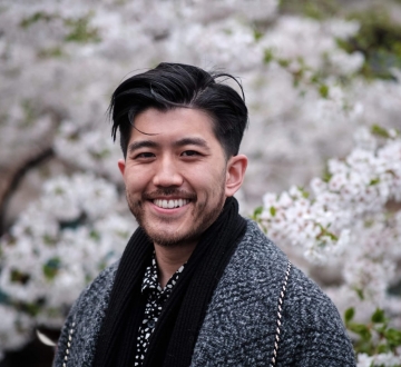 Taoxin (Xin) Wang standing in front of white blossoms