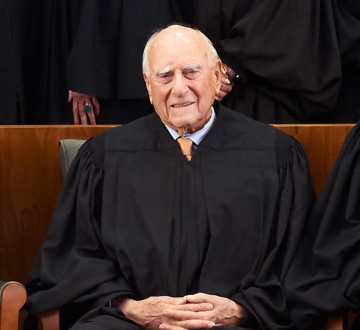 Older man in tie and black judge's robe