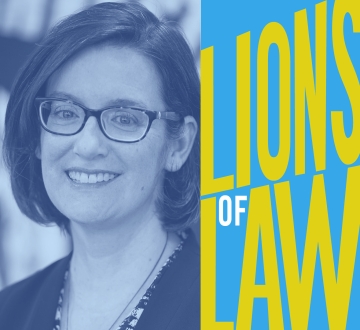 Woman with dark hair and glasses with graphic reading Lions of Law