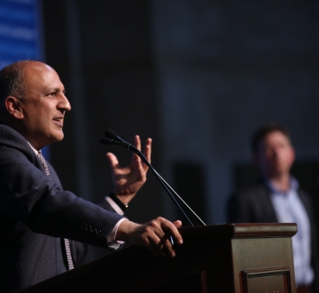 Man speaking and gesturing at podium
