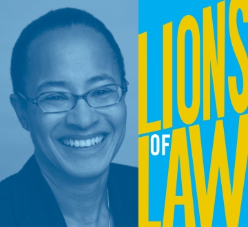 Woman with glasses and cropped haircut with Lions of Law logo