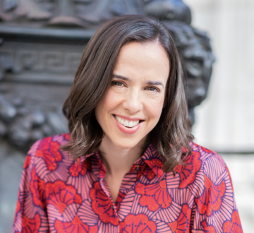 Woman with brown hair in colorful patterned blouse