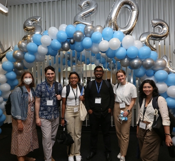 Six members of the class of 2025 pose in front of blue and white balloon arch with additional silver balloons that spell out CLS 2025.