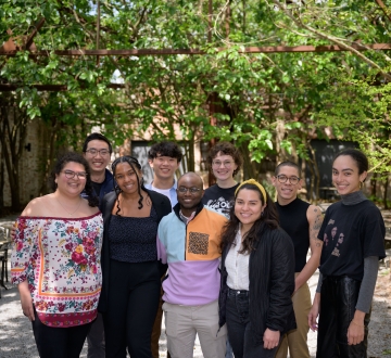 Group of nine law students standing in a shady courtyard