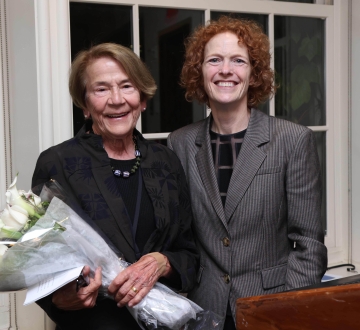 Two women smiling, one with bouquet of flowers
