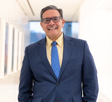 Man with glasses in blue suit and blue tie