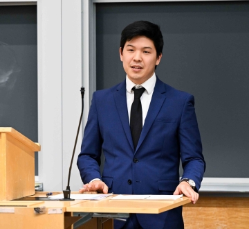 Miles Kim stands behind a podium.