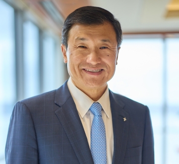 Headshot of a man wearing a blue jacket, white shirt, and blue tie