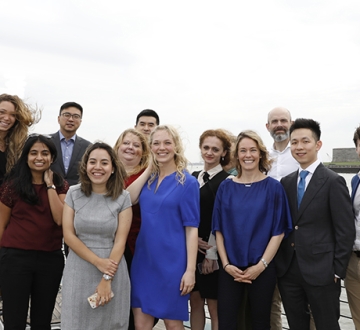 The Executive LL.M. class poses on a boat deck with the Statue of Liberty in the background.