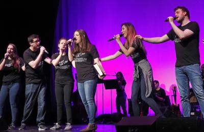 Law Revue students sing with microphones