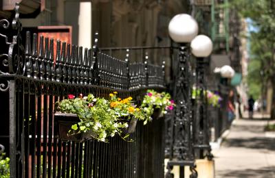 Flower baskets on a wrought iron railing in Morningside Heights