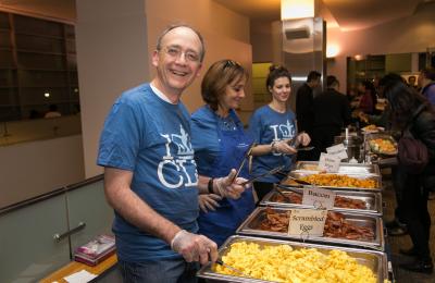 Professors smile and serve food at Midnight Breakfast.