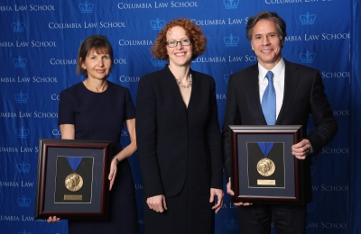 Alison S. Ressler '83 and Antony Blinken '88 hold up their Medal for Excellence awards with Dean Gillian Lester