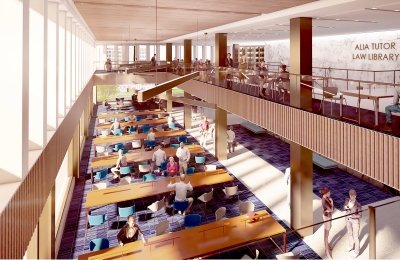 Several long tables stand in front of a bank of windows and beneath a mezzanine.ine