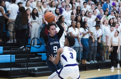 A Columbia Law student holds a basketball overhead.