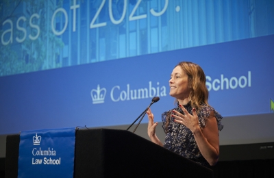 Woman at podium speaking and gesturing
