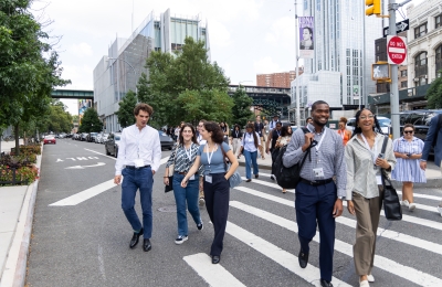 Group of students walking in the street in a striped crosswalk 