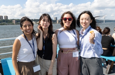 Group of women students smiling against river scene