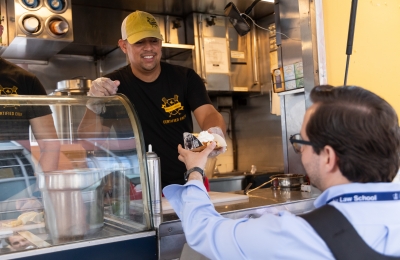 Food truck vendor handing item to student