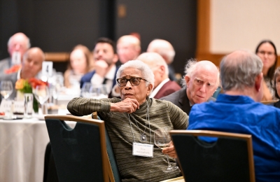 White haired woman turning in chair to listen 