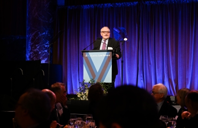 Man with glasses speaking at podium onstage
