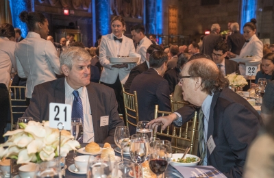 Two men in conversation seated at a table