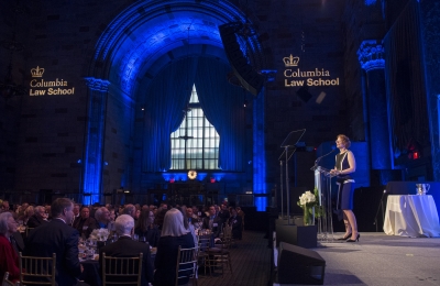 Dean Gillian Lester on stage at Winter Luncheon and people seated at tables